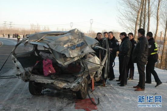 　2月23日，交警與工作人員在事故現場查看損毀的微型面包車。