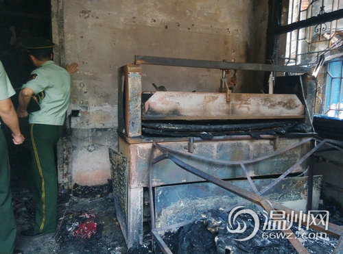 該民房右側有一臺壓模機，地上有布料殘片
