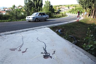 事發處為雙向兩車道，且為彎道。昨日下午，地面上仍殘留著兩道血跡。新京報實習生 盧淑嬋 攝